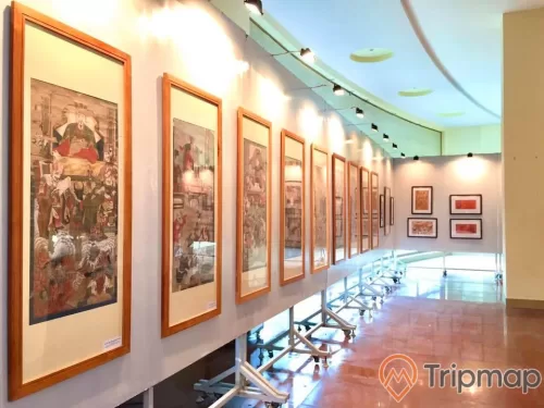 nhiều bức tranh treo trên giá trong bảo tàng